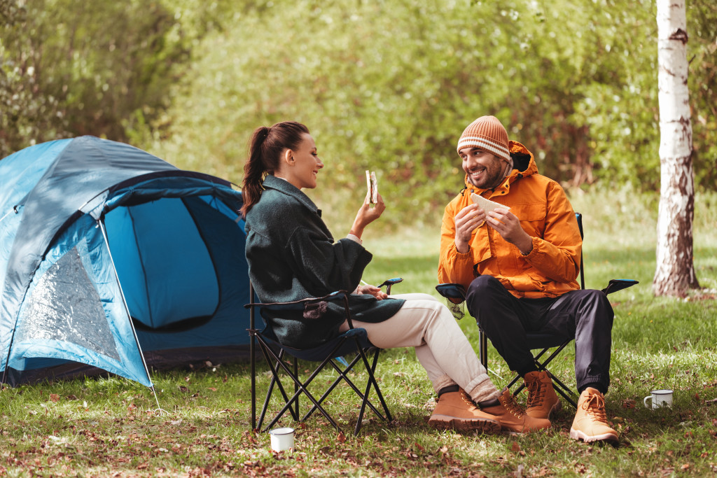 couple eating sandwich while camping