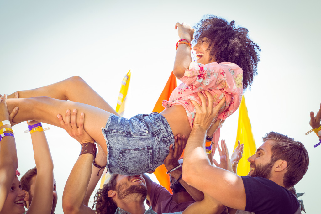 A woman being carried during crowd surfing at festival